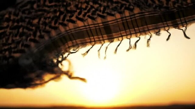 Keffiyeh in the desert at sunset, traditional middle eastern headdress in the wind