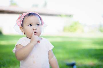 Toddler with headscarf is making quiet gesture during family picnic in green outdoor leisure area where people enjoy concept of calm and peaceful moments