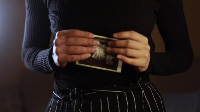 A young woman shows a pregnancy ultrasound scan