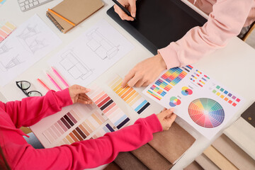 Couple of graphic designers working with color palettes on table, closeup
