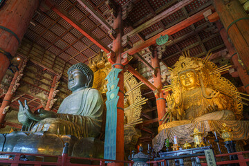 Nara, Japan - Sep 26 2024, Panoramic view of the Sitting Buddha Vairochana, a fifteen-meter bronze statue of Buddha, and a side-standing gilded statue of Buddha, at Todaiji Temple, Nara, Japan
