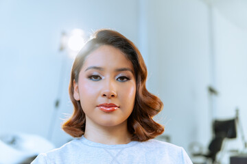 Young latin woman showing her make-up in beauty salon
