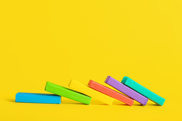 Many colorful plasticine on yellow background