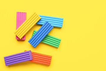 Many colorful plasticine on yellow background