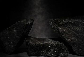 black stones with texture on dark background for cosmetic podium backdrop