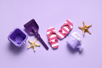 Decorative flip-flops, starfishes, toy shovel and bucket on lilac background