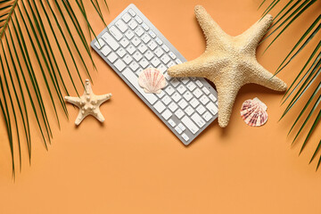Computer keyboard with palm leaves, shells and starfishes on orange background