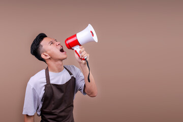 Energetic Barista Guy Wearing Brown Apron Yelling Through Bullhorn Calling Out To The Side