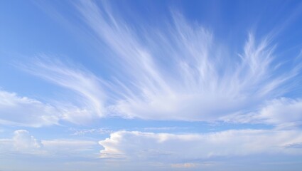 Expansive blue sky with delicate wispy white clouds stretching across the horizon in a serene and calm atmosphere