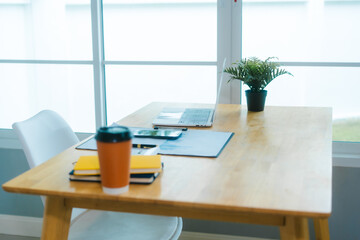 .A clean, modern home office features a laptop, plant, and organized desk, ready for productive...