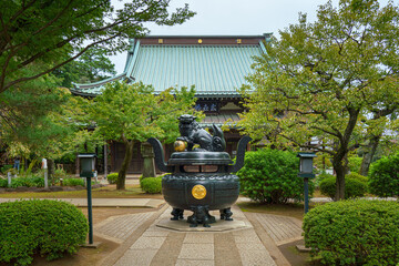Tokyo, Japan - Sep 30 2024, Panoramic view of the bronze incense burner decorated with a lion statue, surrounded by trees, on road to Gotokuji Temple, without people, at daytime, Tokyo, Japan