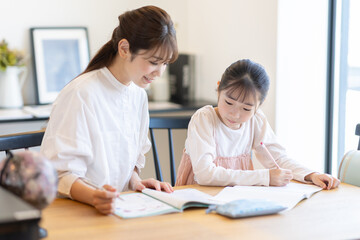 子供の勉強を見る母