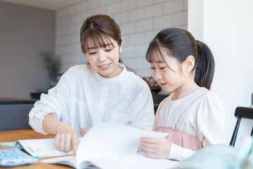 子供の勉強を見る母