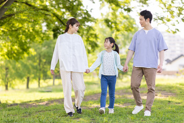 手を繋いで歩く家族