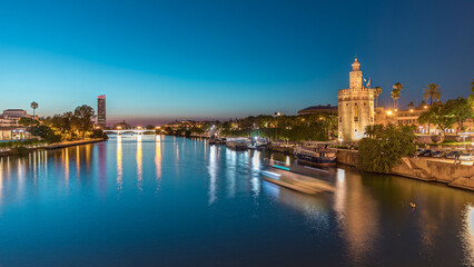 Naklejka premium Guadalquivir River near Torre del Oro day to night timelapse in Seville, Spain