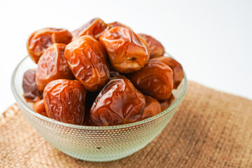 Dates fruit sukari or kurma sukari, in bowl isolated on white background