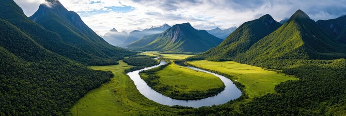 Aerial view of a green valley framed by towering mountain peaks, with a winding river reflecting the sky