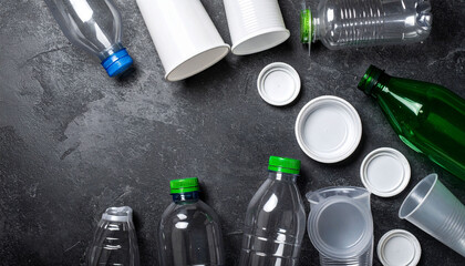 Recycled Plastic Bottles and Cups on Dark Surface Environmental Awareness Concept