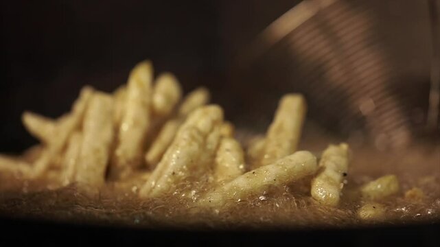 Closeup shot of deep frying potatoes. Oil boiling closeup.