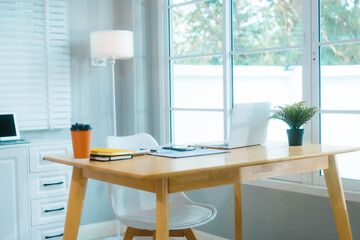 
A clean, modern home office features a laptop, plant, and organized desk, ready for productive...