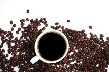 Freshly brewed black coffee in a white cup beside roasted beans on rustic table, capturing morning aroma, warmth, and cozy atmosphere.