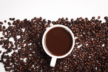 Freshly brewed black coffee in a white cup beside roasted beans on rustic table, capturing morning aroma, warmth, and cozy atmosphere.
