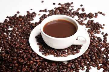 Freshly brewed black coffee in a white cup beside roasted beans on rustic table, capturing morning aroma, warmth, and cozy atmosphere.