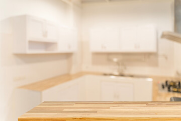 Wood tabletop on blurred modern kitchen interior background, empty counter mockup for product...