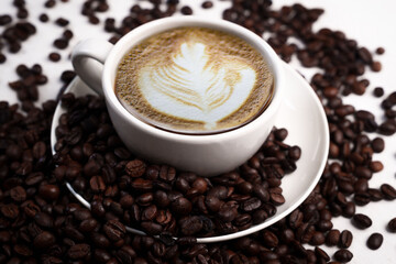 Freshly brewed black coffee in a white cup beside roasted beans on rustic table, capturing morning aroma, warmth, and cozy atmosphere.
