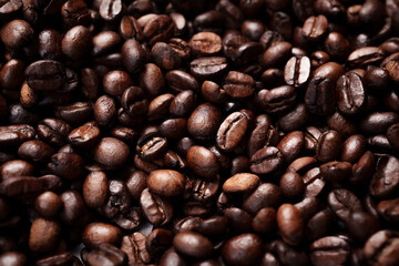 Close-up of roasted brown coffee beans piled together, showcasing rich texture, aroma, and freshness on a white studio background.