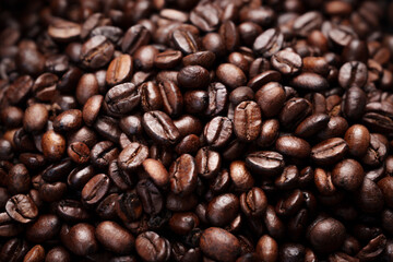 Close-up of roasted brown coffee beans piled together, showcasing rich texture, aroma, and freshness on a white studio background.
