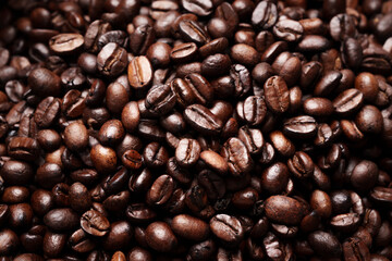 Close-up of roasted brown coffee beans piled together, showcasing rich texture, aroma, and freshness on a white studio background.