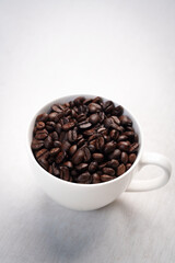 Close-up of roasted brown coffee beans piled together, showcasing rich texture, aroma, and freshness on a white studio background.