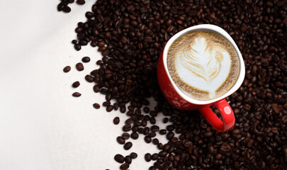 Freshly brewed black coffee in a white cup beside roasted beans on rustic table, capturing morning aroma, warmth, and cozy atmosphere.