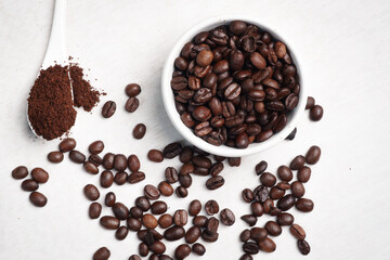 Close-up of roasted brown coffee beans piled together, showcasing rich texture, aroma, and freshness on a white studio background.