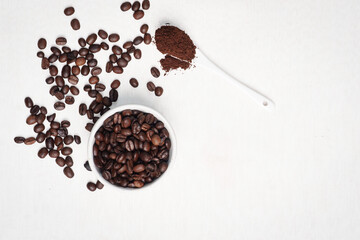 Close-up of roasted brown coffee beans piled together, showcasing rich texture, aroma, and freshness on a white studio background.