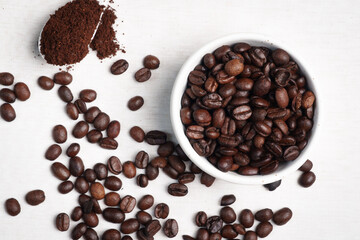 Close-up of roasted brown coffee beans piled together, showcasing rich texture, aroma, and freshness on a white studio background.
