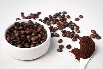 Close-up of roasted brown coffee beans piled together, showcasing rich texture, aroma, and freshness on a white studio background.