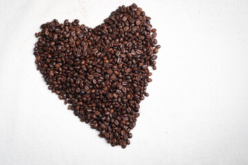 Close-up of roasted brown coffee beans piled together, showcasing rich texture, aroma, and freshness on a white studio background.