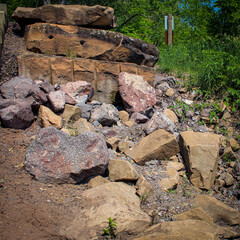 Rip rap stones used to protect soil from erosion on a riverbank. soil stabilization and environmental design element. beauty in nature. different types and sizes of rocks.