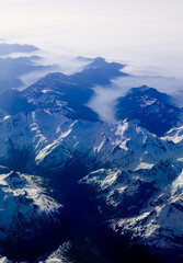 An aerial shot of the Swiss Alps mountain range on a sunny day with blue skies