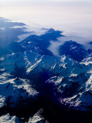 An aerial shot of the Swiss Alps mountain range on a sunny day with blue skies