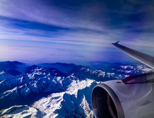An aerial shot of the Swiss Alps mountain range on a sunny day with blue skies