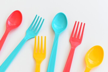 colorful spoon and fork isolated on white background, plastic cutlery for picnic