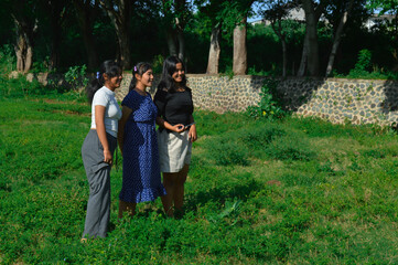 Fototapeta premium The group of teenage girls stands closely together as they examine their natural surroundings.