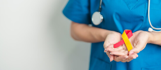 World hepatitis day awareness month, 28 July. Doctor holding Red and Yellow ribbon. Liver cancer, Jaundice, Cirrhosis, Failure, Enlarged, Hepatic Encephalopathy and Health concept