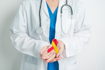 World hepatitis day awareness month, 28 July. Doctor holding Red and Yellow ribbon. Liver cancer,...