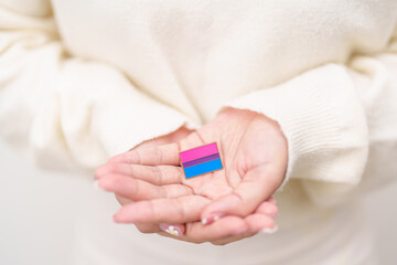 Bisexuality Celebrate Day and LGBT pride month, LGBTQ or LGBTQIA concept. Hand holding purple, pink and blue flag shape for Lesbian, Gay, Bisexual, Transgender, Queer, Pansexual, Marriage Equality Law