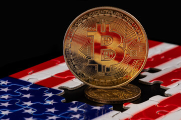 A coin with the Bitcoin cryptocurrency symbol against the backdrop of a puzzle-shaped US flag