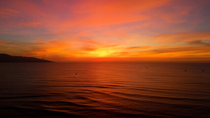 Fototapeta premium Golden sunrise painting the sky with vibrant hues over the calm ocean in da nang, vietnam, creating a breathtaking spectacle of nature's beauty